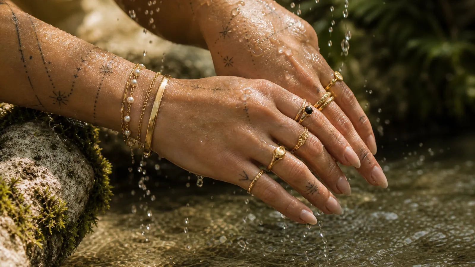 Hands styled with Arley London rings and bracelets under fresh water droplets