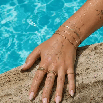 Gold Arley Berlin jewellery worn beside a swimming pool